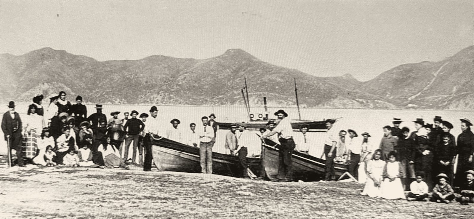 Whalers and their families on the beach at Te Awaiti, with whaleboats drawn up
